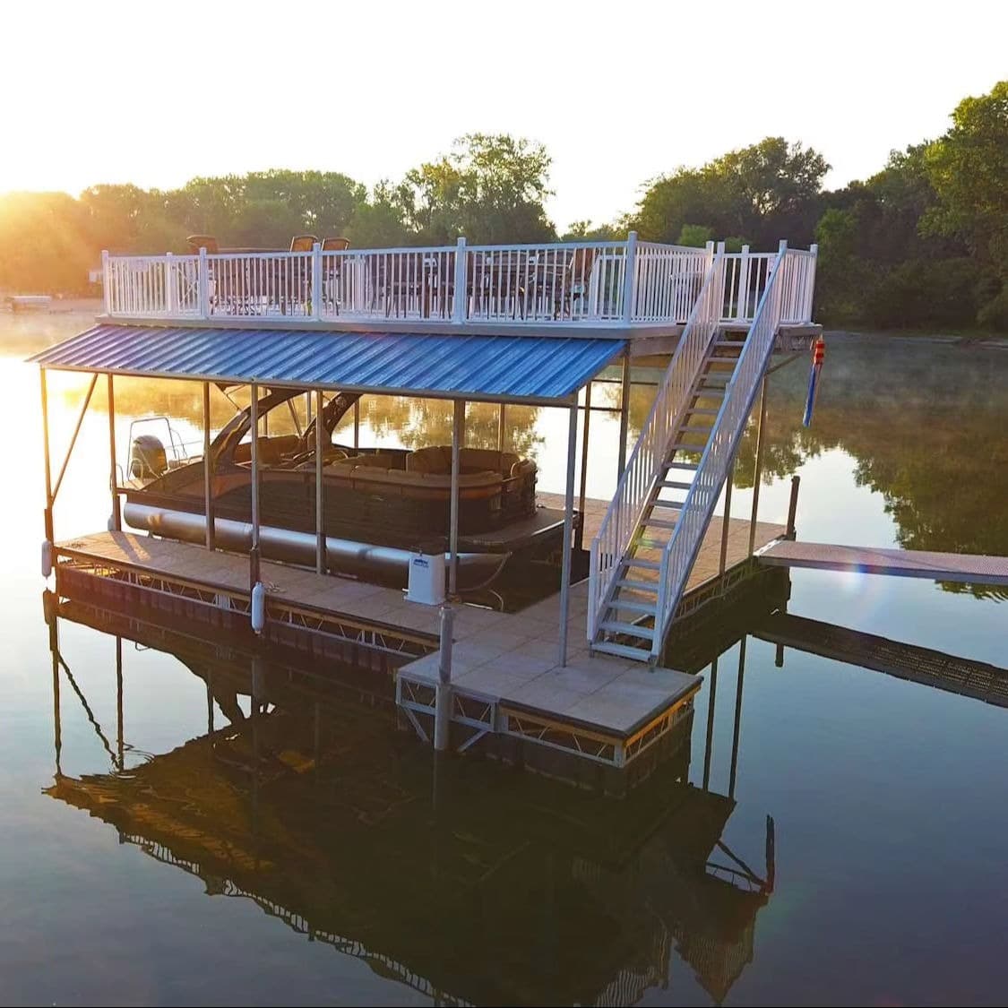 Sunrise dock house with covered slip and rooftop entertaining deck